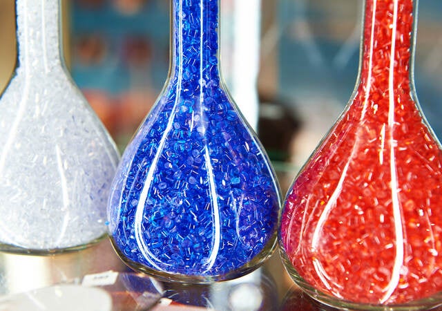 Colorful plastic granular polymer in glass flasks