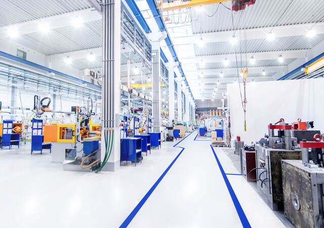 View overlooking the digitally controlled lighting of a brightly lit modern factory floor.