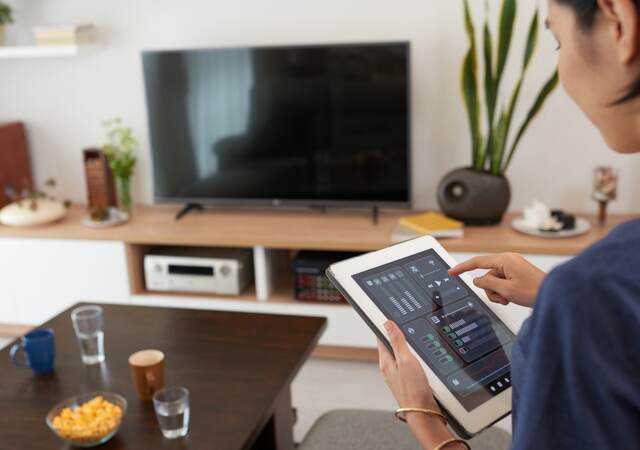 Woman controlling a smart home system with a tablet 