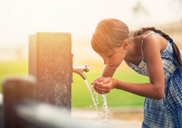 Girl drinking water from fountain