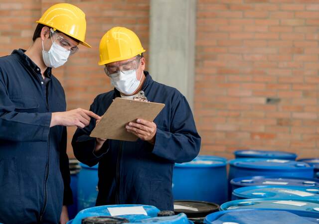 Men in PPE working in chemical warehouse