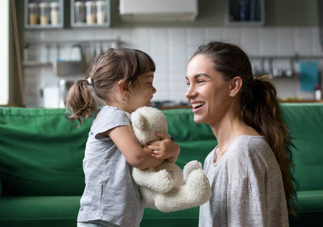 A mother plays in the living room with her child