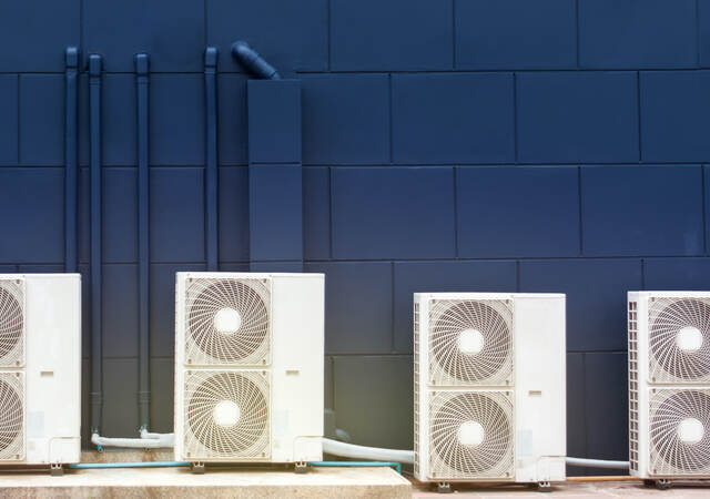 Four white computer speakers on a table