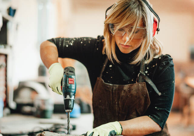 Female carpenter using power tool