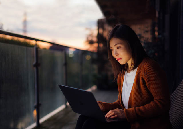 Woman using a laptop at dusk