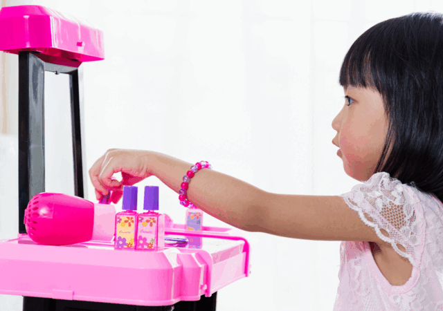 Little girl playing with cosmetic toys