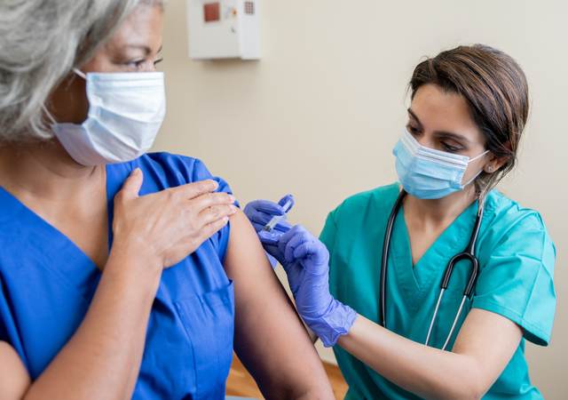 Nurse provides vaccine to elderly woman