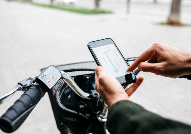 Man with e-bike using a smartphone for navigation