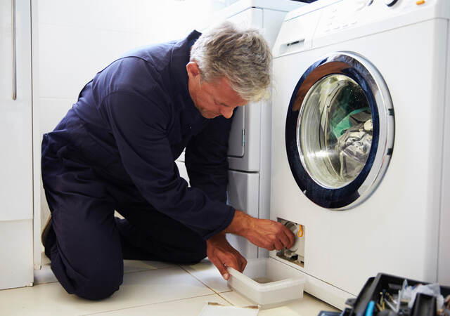 Repairman working on clothing dryer