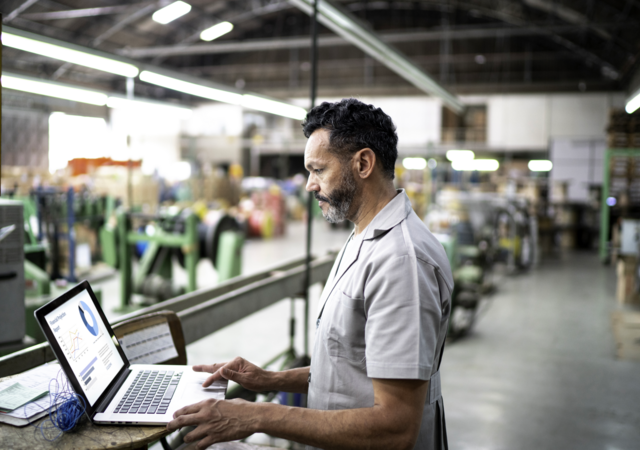 Technician using laptop while working in a factory