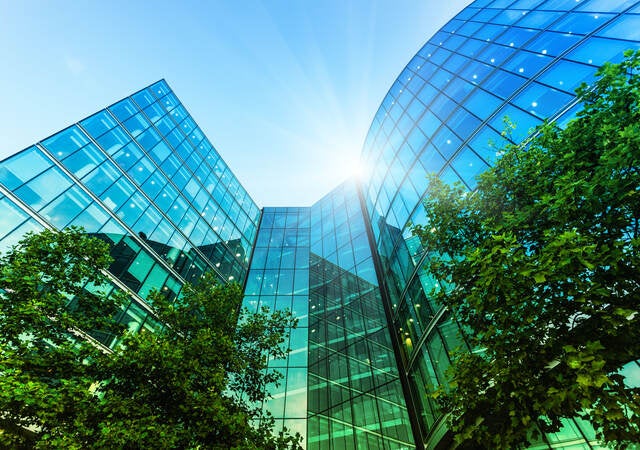 Low angle view of multi-story glass front modern office building