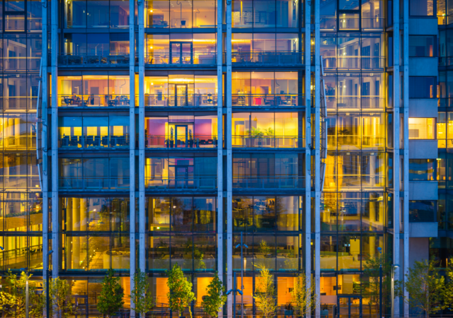 Business office building windows illuminated at dusk