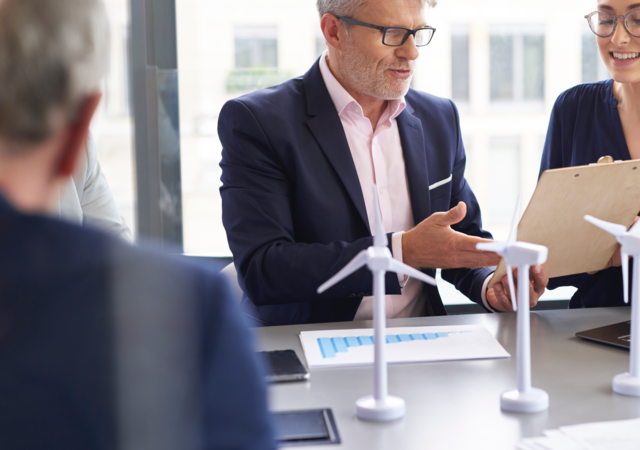 Business people discussing a wind turbine model