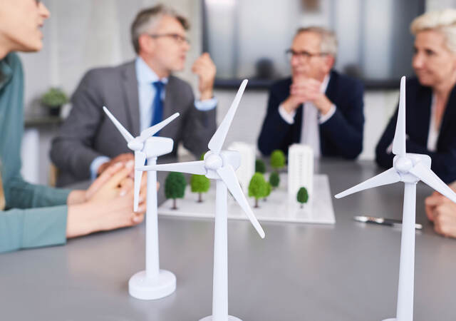 Scale models of wind turbines on a desk during a planning meeting