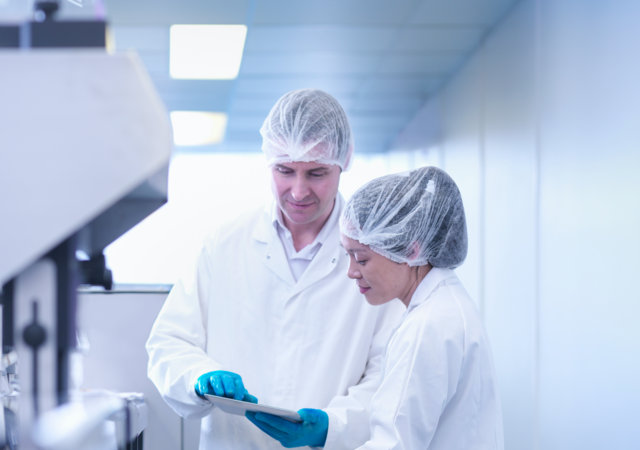 Man and woman scientists inspecting product in pharmaceutical factory