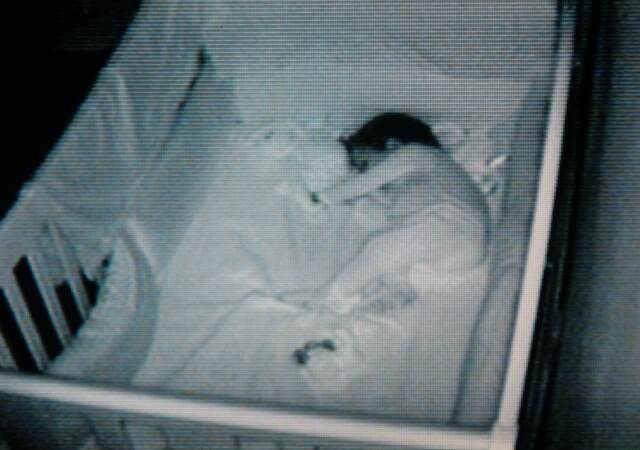 A baby sleeping in their crib