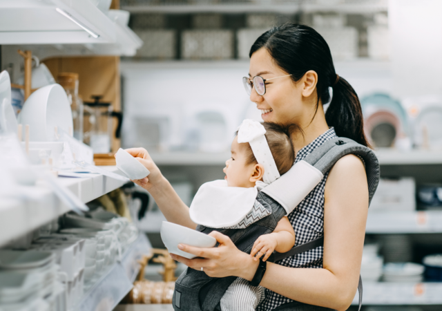 Woman shopping for dishes with her baby