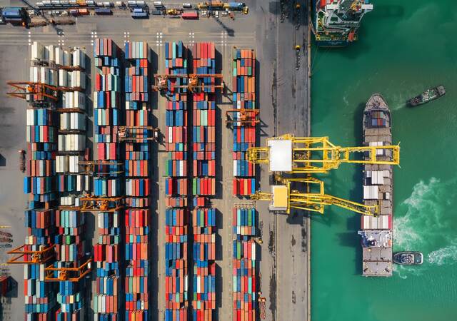 Overhead view of shipping containers being moved from a ship