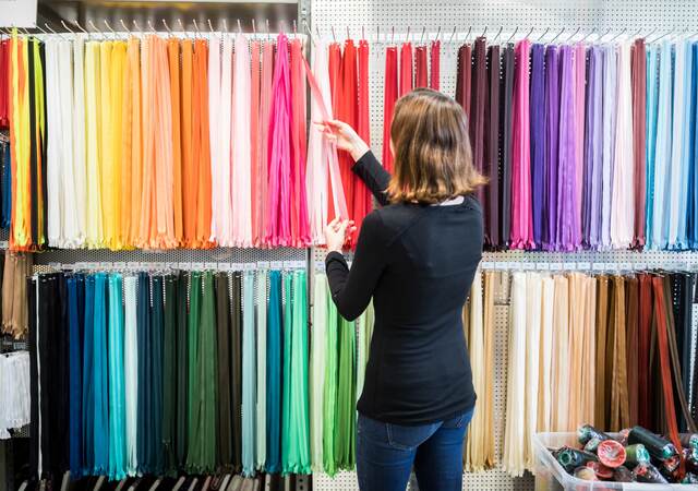 Woman examining colorful zippers