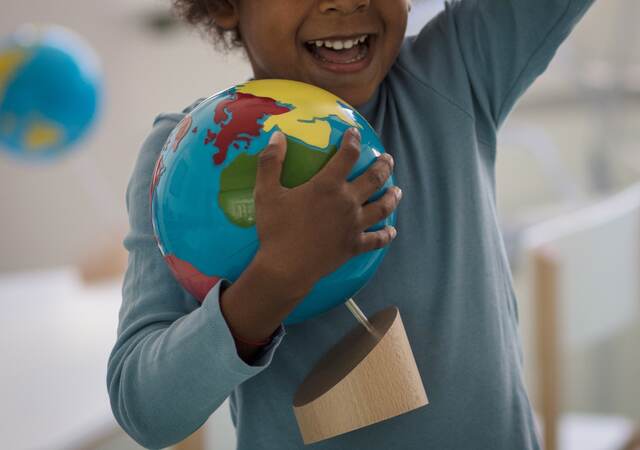 Child holding a toy ball.