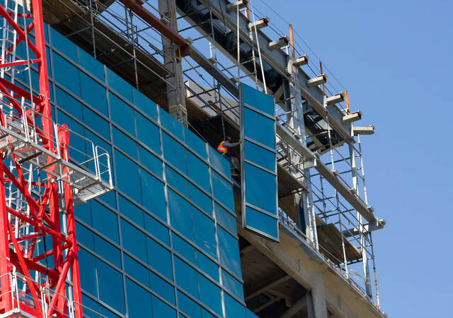 Lifting glass into place while constructing a commercial building