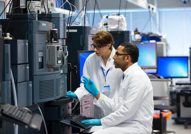 Laboratory technicians using specialized equipment for measuring chemicals