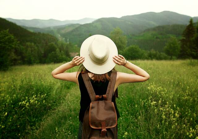 Woman traveler with backpack in nature