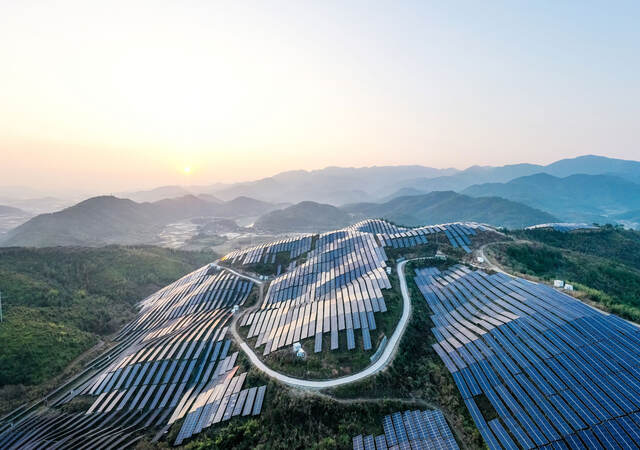 Aerial view of a solar power plant on top of a mountain.