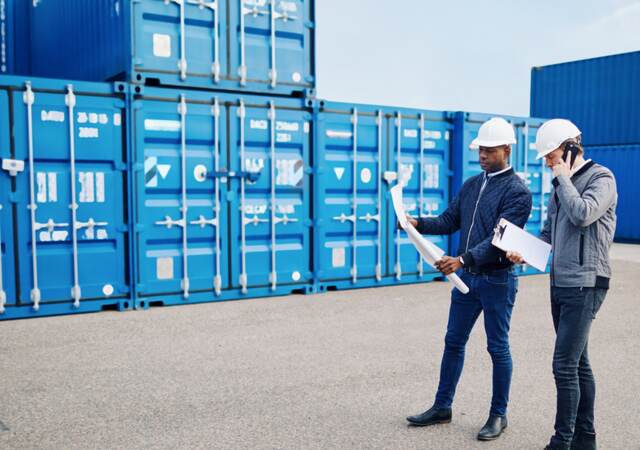 Logistics workers discussing paperwork.