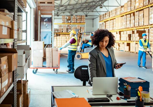 Person working on a laptop in a warehouse