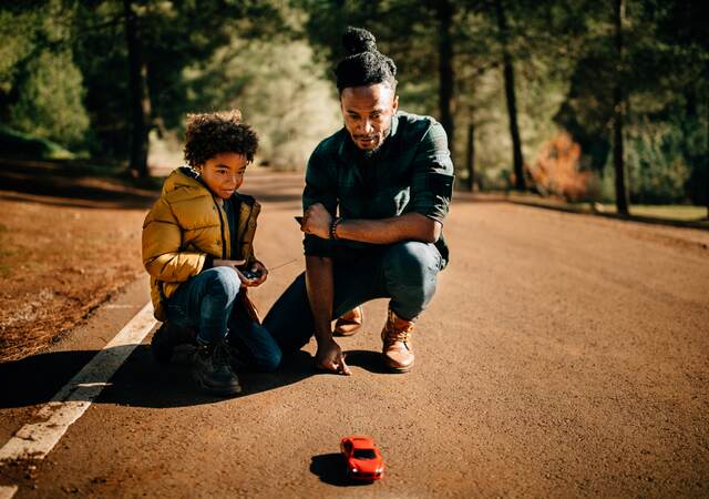 Father and son watch a radio-controlled car together