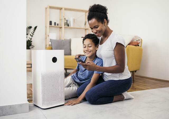 African American woman and her son setting up the intelligent home system on a smartphone.