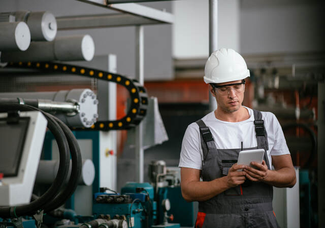 Worker in hardhat working with a tablet