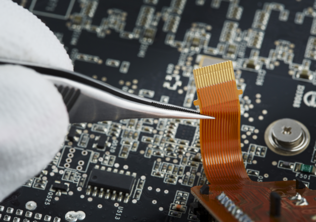 Close up of human hand repairing printed circuit board