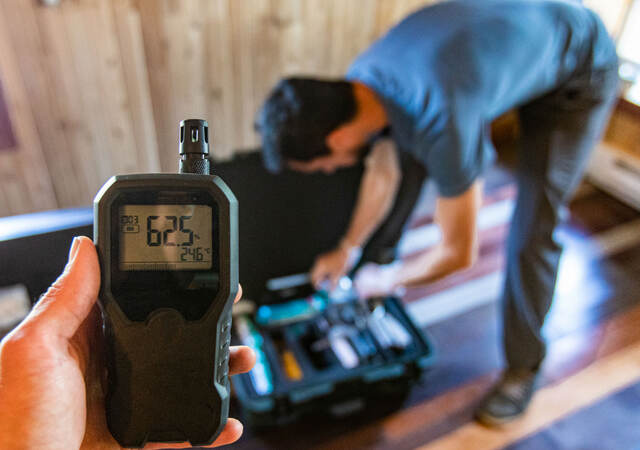 Technicians use a device to measure moisture levels