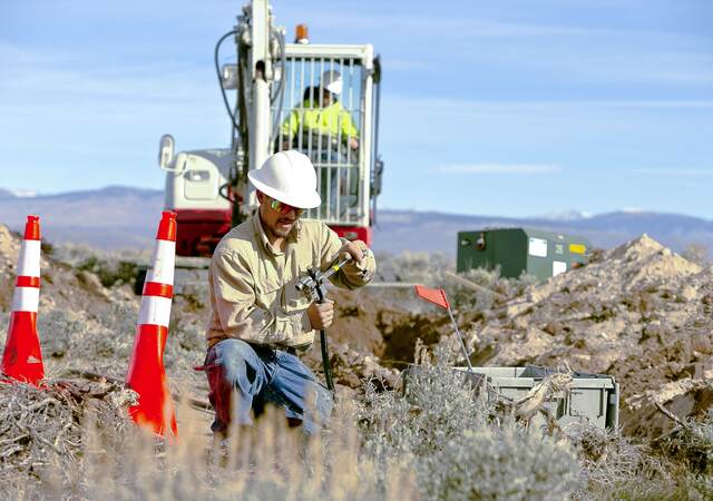 Worker installing cables for underground distribution.