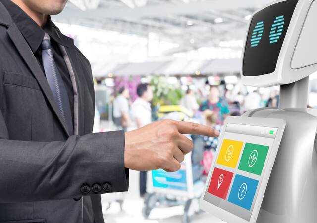 Businessman using autonomous personal assistant robot for navigation at the airport