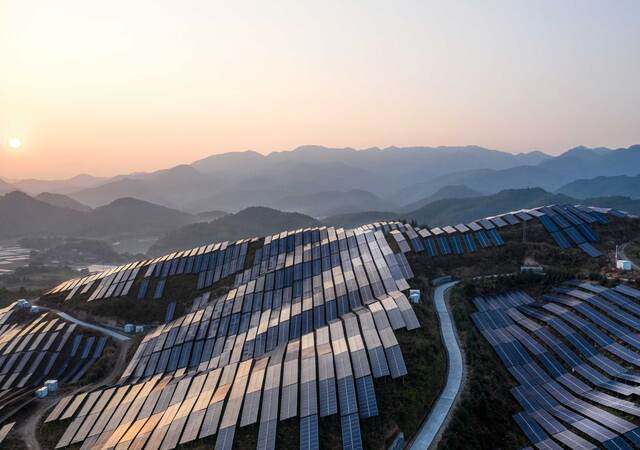 Aerial view of the solar power plant on the top of the mountain at sunset