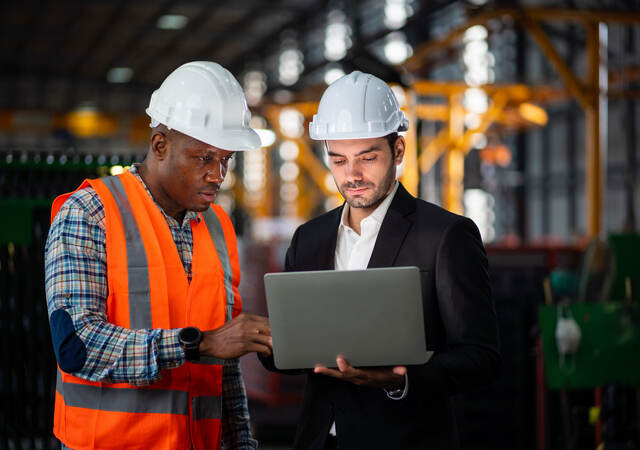 Two engineers looking at a laptop