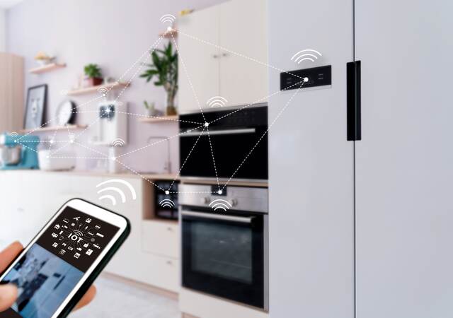 View of smart home from kitchen with appliances being operated by a mobile device.