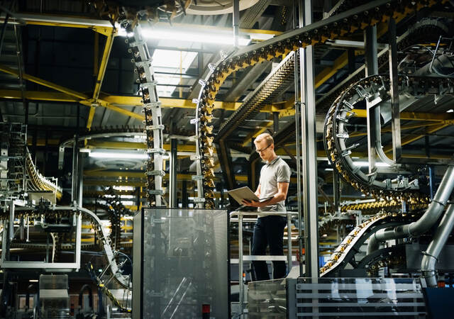 Engineer with laptop in a factory