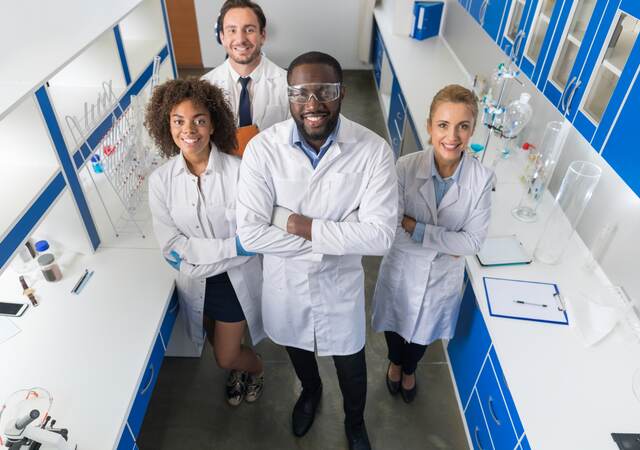 African American Scientist With Group Of Researchers In Modern Laboratory Happy Smiling, Mix Race Team Of Scientific Researchers In Lab.