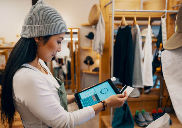 Retail shop clerk taking a mobile credit card payment on a digital tablet