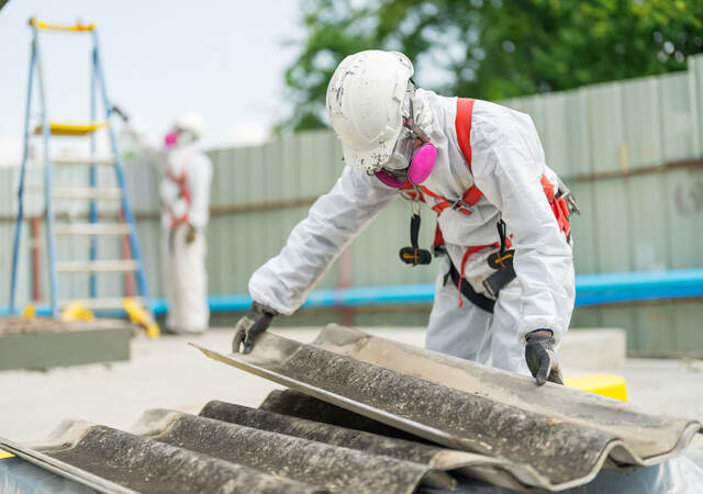 An employee follows the correct safety procedure while handling asbestos. 