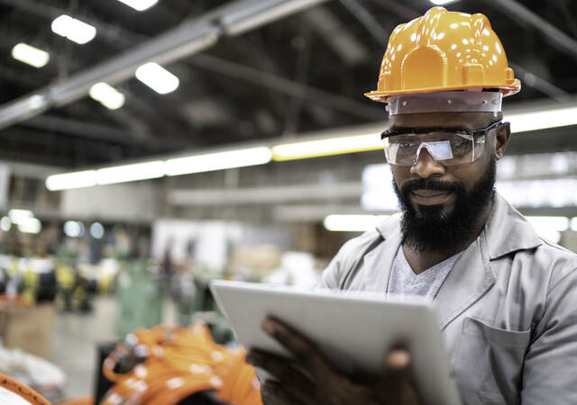 Man working with a digital tablet in a factory