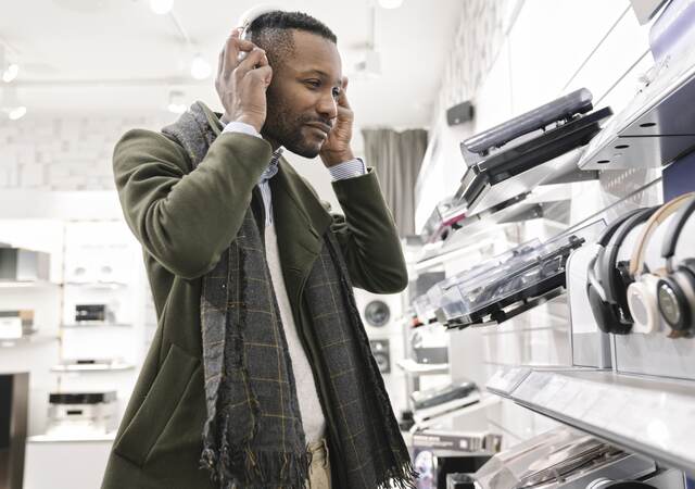 Man trying on headphones in a store.