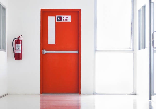 Red emergency fire door with labels