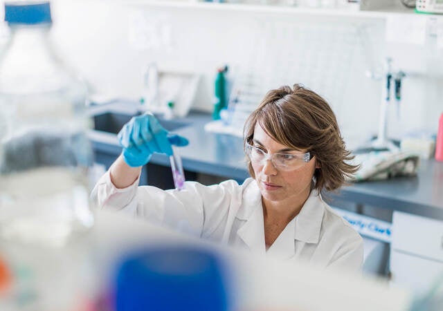 Scientist inspecting sample in a test tube