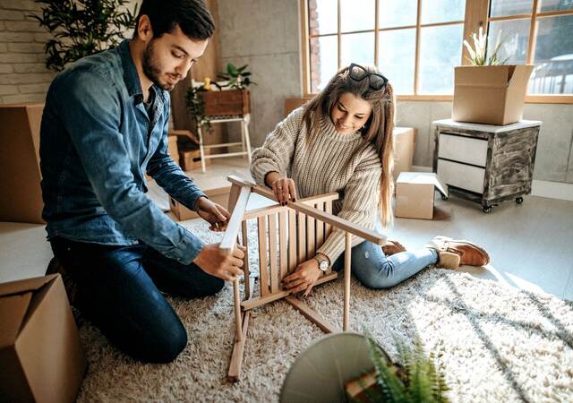 Young couple assembling furniture for new home