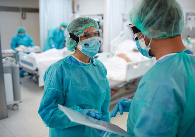 Two doctors talking and wearing PPE